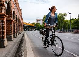 A bicycle rider turning their head to check for traffic